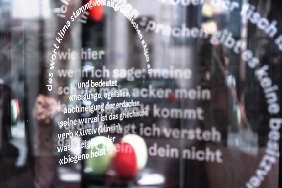 fragments of poetic text on a rotating glass door: scenography festival center of Klima Biennale Wien at KunstHausWien by JASCHA&FRANZ and Andrea Grill
